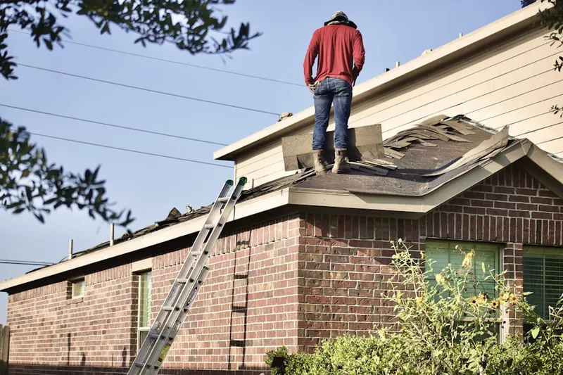 Professional roofer working on a residential roof in Marquette